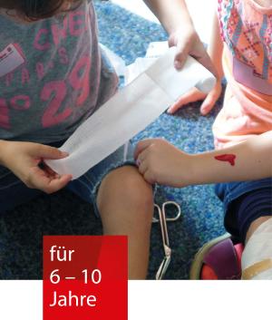 ein Kind verbindet einem anderen Kind eine aufgemalte Wunde
