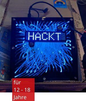 ein tablet auf dem ein blaues Feuerwerk zu sehen ist und der Schriftzug "HACKT"