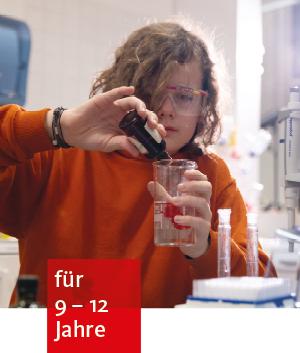 ein Kind mit Schutzbrille in einem Labor füllt aus einer kleinen Flasche eine Flüssigkeit in einen Messbecher