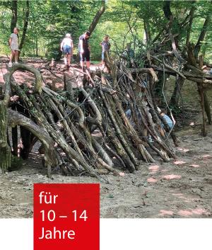 Mehrere Baumstämme und Hölzer lehnen gegen einen Wall im Wald. Kinder stehen oberhalb
