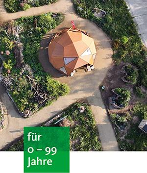 in einem großen Garten mit breiten Wegen steht ein Holziglu