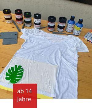 Weißes T-Shirt mit verschiedenen Farben zum Siebdruck im Hintergrund