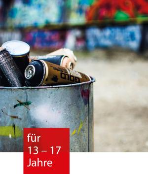 Spraydosen in einem silbernen Eimer vor einer Graffiti Wand